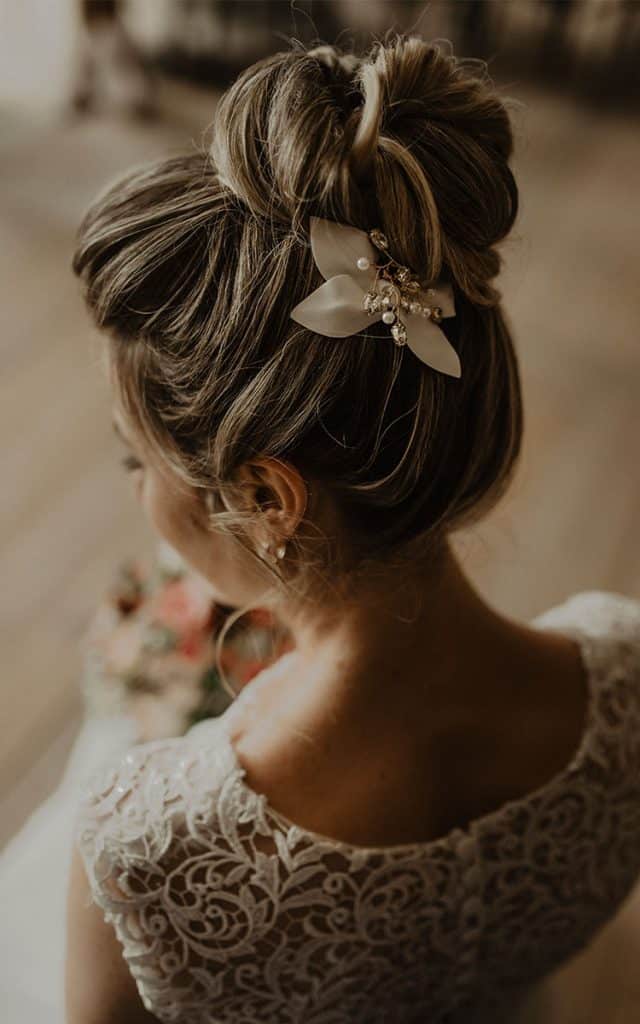 Ein hoher Dutt als Brautfrisur mit schlichtem Haarschmuck