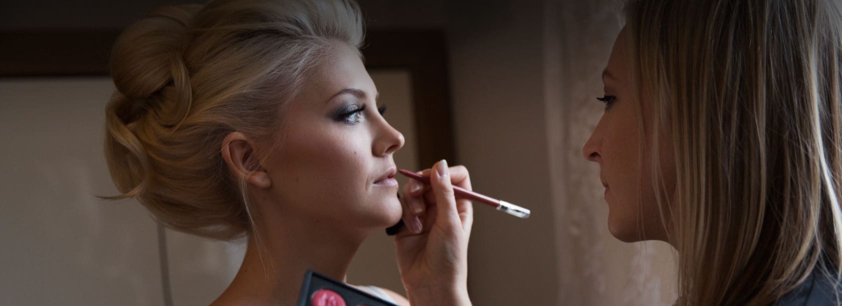 Make-up Artist schminkt Braut Hochzeitsmake-up
